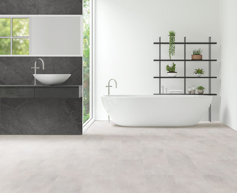 stone look luxury vinyl tile flooring in bathroom with stone accents and plants.